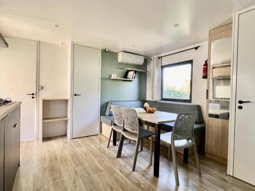 Una cocina y un comedor con mesa y sillas. en MobilHomeTorreilles, en Torreilles