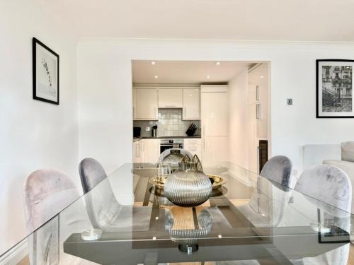 a dining room with a glass table and chairs at Covent Garden Residence in London