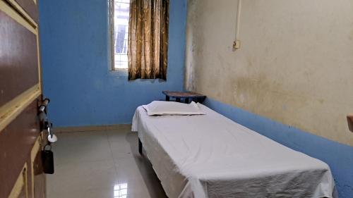 a hospital room with a bed and a window at Sangita Lodge in Ratnagiri