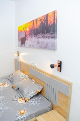 a bedroom with a bed with a painting on the wall at CHROME Résidences Fidjrossè PLAGE in Cotonou