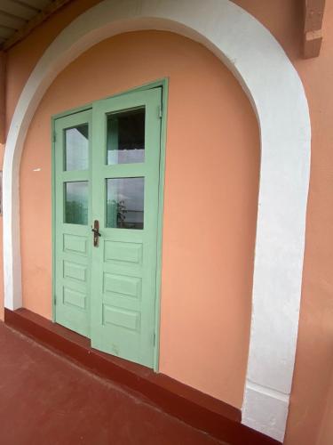 a green door on the side of a building at CASA da Baía by NaturAlegre in São Tomé