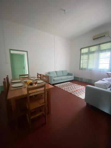 a living room with a table and a couch at CASA da Baía by NaturAlegre in São Tomé