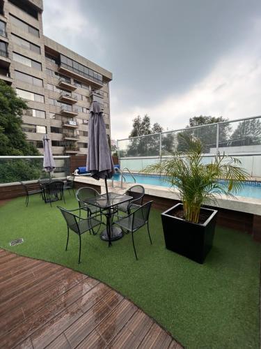 a patio with a table and chairs and a pool at Hermoso depto c/alberca y gym Polanco in Mexico City
