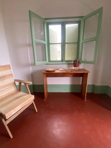 a room with a table and a chair and a window at CASA da Baía by NaturAlegre in São Tomé