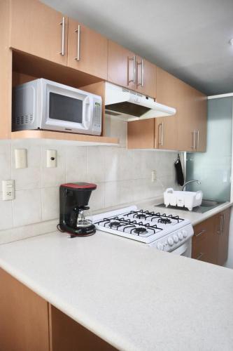 a kitchen with a stove and a microwave at Hermoso depto c/alberca y gym Polanco in Mexico City