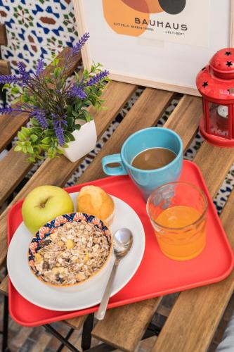 a red tray with a plate of breakfast food and a cup of coffee at La Pimentera Rooms in Córdoba