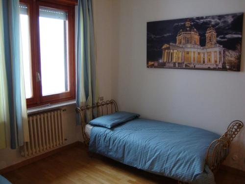a bedroom with a bed in a room with a window at La Matinera Apartment in Pecetto