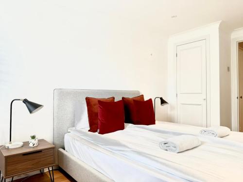 a bedroom with two beds with red pillows at Covent Garden Residence in London