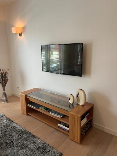 a living room with a flat screen tv on a wall at l'abri du bonheur in Lampertheim