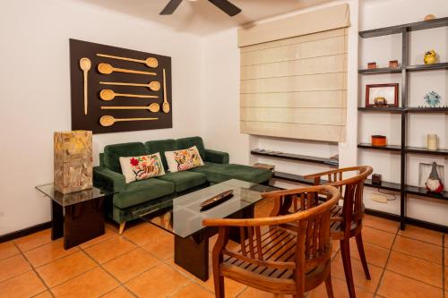 a living room with a green couch and two chairs at Apartamento amplio en zona ideal a 5min de WALLMART in Cancún