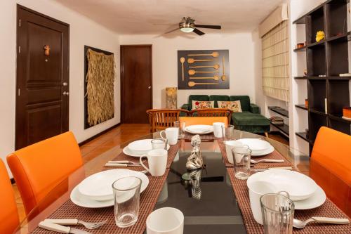 a dining room with a table and orange chairs at Apartamento amplio en zona ideal a 5min de WALLMART in Cancún