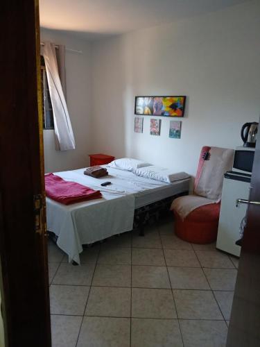 une chambre avec un lit d'hôpital et une chaise dans l'établissement Quarto com banheiro casa da Mari, à Maringá