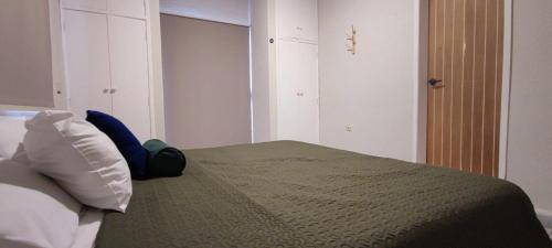 Un dormitorio con una cama con una manta verde. en Casa Eclipse, en Cancún
