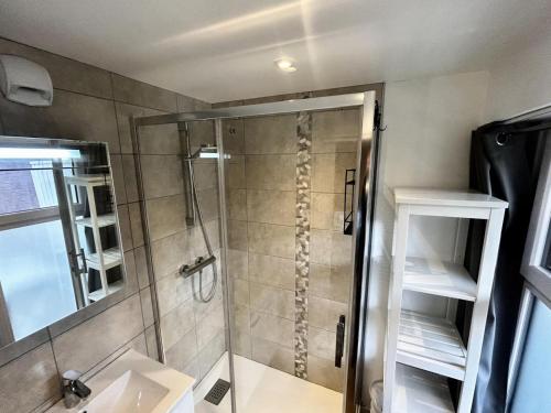 une douche avec une porte vitrée dans une salle de bain dans l'établissement Résidence Oisans - Studio rénové avec coin montagne, balcon exposé Sud MAE-5174, aux Menuires
