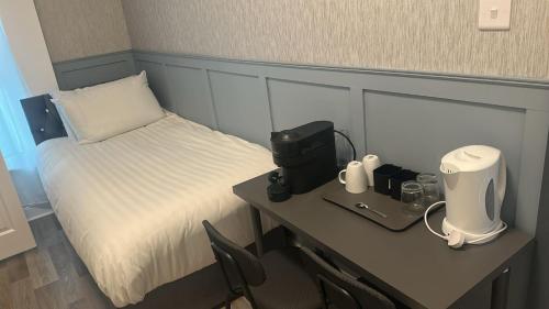 a room with a bed and a desk with a coffee maker at Saint Annes Guest House - 22 Berkeley in Dublin