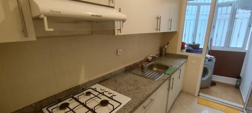 a kitchen with a sink and a stove top oven at Dyar alboughaz in Hajreien