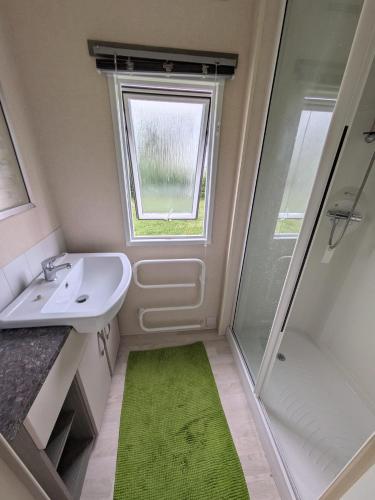 un piccolo bagno con lavandino e doccia di Village 35 a Lingreville
