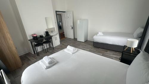 Un dormitorio con una gran cama blanca y un escritorio. en Saint Annes Guest House - 22 Berkeley, en Dublín