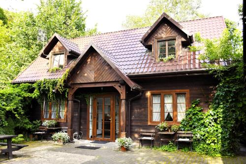a wooden house with a table and benches in front of it at Pokoje gościnne Fermata in Kazimierz Dolny