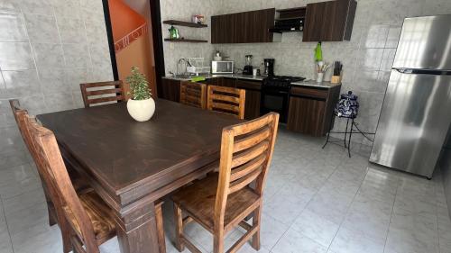 プエブラにあるPuebla centro casa Peerzaのキッチン(木製テーブル、椅子、冷蔵庫付)