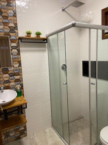 a bathroom with a shower and a sink at Chalés Rancho Fênix in Palmeiras