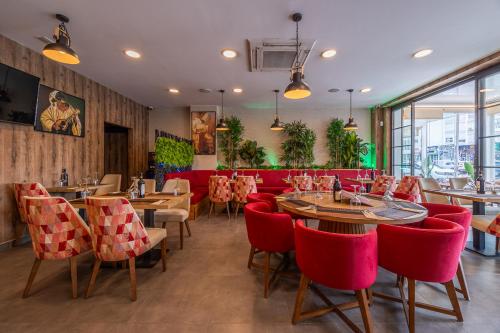 a restaurant with red chairs and tables and a red couch at Hotel Marina Benalmádena in Benalmádena