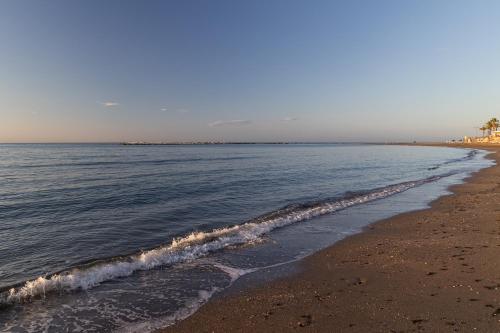 a beach with the ocean and the shoreline at Hotel Marina Benalmádena in Benalmádena