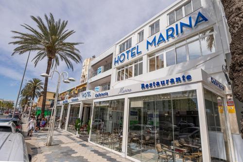a building with a palm tree in front of it at Hotel Marina Benalmádena in Benalmádena