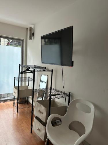 a living room with a flat screen tv on a wall at Linda Habitacion privada con balcon en Polanco in Mexico City
