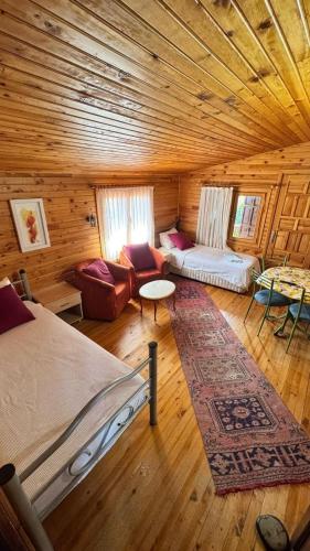 a room in a log cabin with a bed and a couch at Turkuaz Bungalows in Cıralı