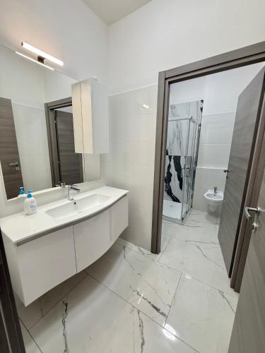 a white bathroom with a sink and a toilet at Luna Guest House in Pisa
