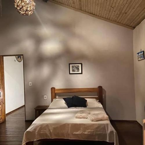 a bedroom with a bed and a chandelier at Barefoot KiteHouse in Luis Correia