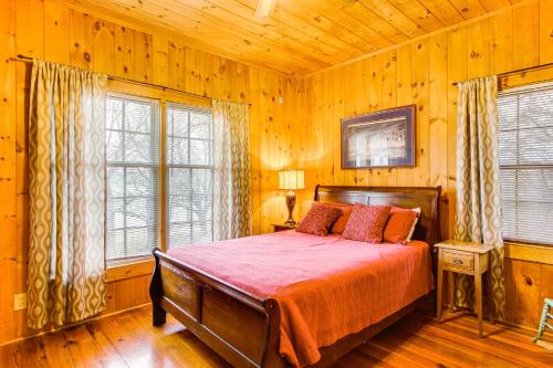 a bedroom with a bed in a room with wooden walls at Private Dock and Porch Serene Lake Greenwood Escape in Greenwood
