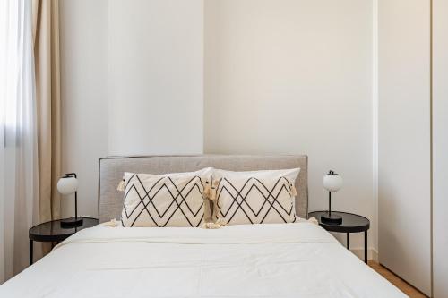 a bedroom with a white bed with two tables at YAMAS Urban Living SEQUOIA Residence in Limassol