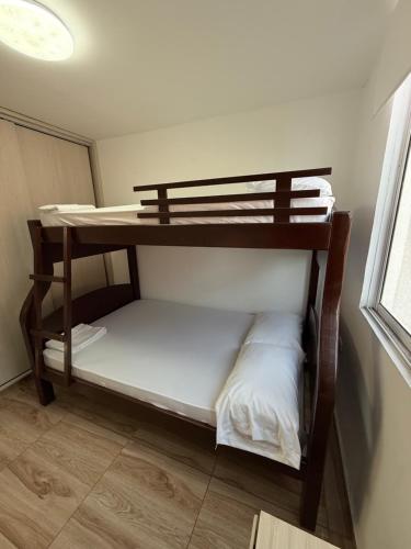 two bunk beds in a room with a window at Apartamento Turistico Bosaso in Villavicencio