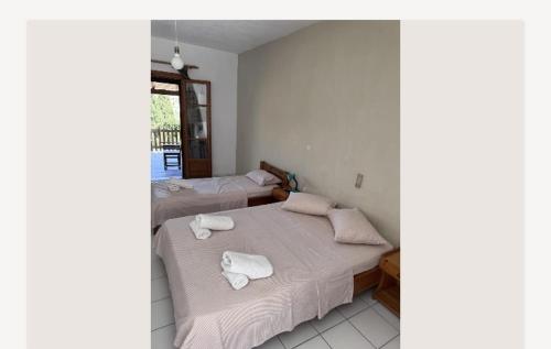 a bedroom with two beds with towels on them at Ευάγγελος Πολίτης in Pisses