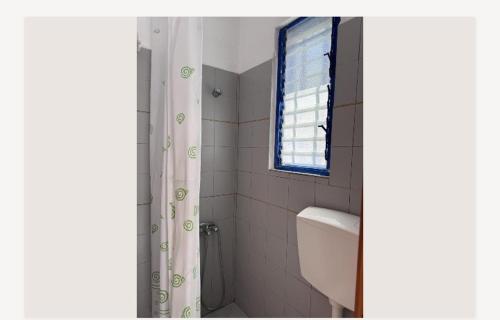 a bathroom with a toilet and a window and a shower at Ευάγγελος Πολίτης in Pisses