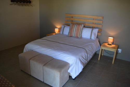 a bedroom with a large bed with two lamps at Travellers Rest in Prince Albert