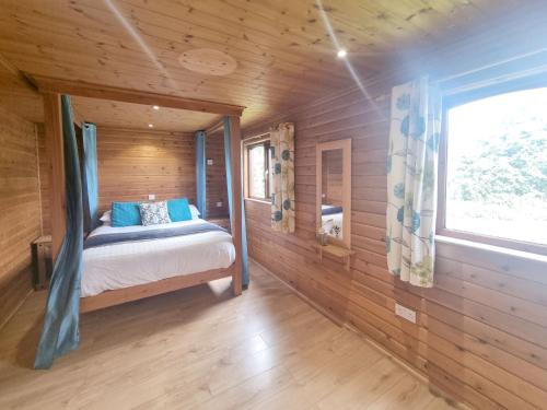 a bedroom with a bed in a wooden cabin at Oak 9 Hot Tub in Garton