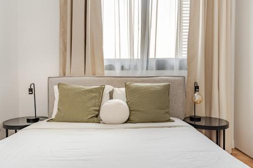 a bedroom with a bed with two side tables at YAMAS Urban Living SEQUOIA Residence in Limassol