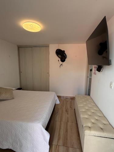 a bedroom with two beds and a flat screen tv at Apartamento Turistico Bosaso in Villavicencio