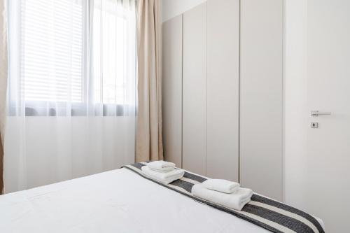 a bedroom with a bed with two towels on it at YAMAS Urban Living SEQUOIA Residence in Limassol