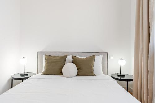 a bedroom with a white bed with two side tables at YAMAS Urban Living SEQUOIA Residence in Limassol