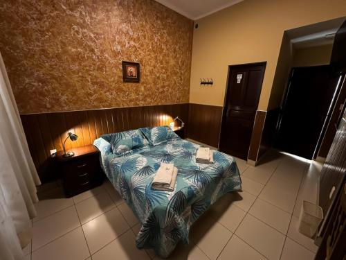a bedroom with a bed with a blue comforter at Mitru Express Tupiza in Tupiza