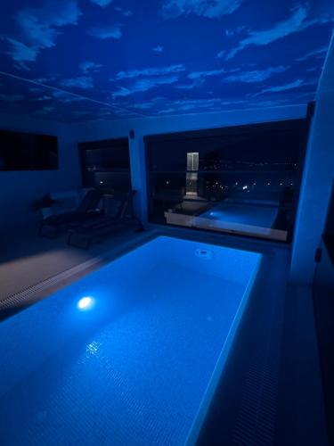 a large swimming pool in a room with a blue lighting at S-Penthouse in Herceg-Novi