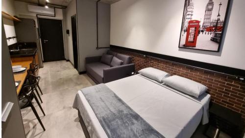 a bedroom with a bed and a brick wall at APTO Studios in Itajaí