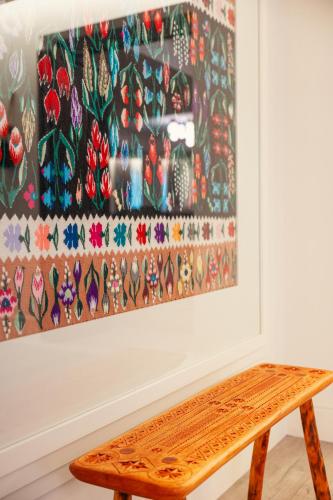 a wooden bench in front of a painting at Armonia by Aristocratis in Tîrgu Neamţ