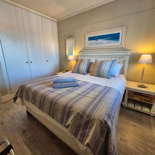 a bedroom with a large bed with blue pillows at South Quay no 6 in Knysna