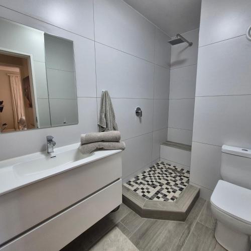a white bathroom with a sink and a toilet at South Quay no 6 in Knysna