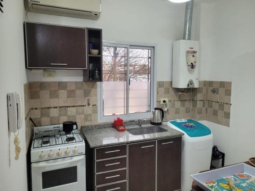 a small kitchen with a stove and a sink at Depto con balcón y mucha luz en CABA in Buenos Aires